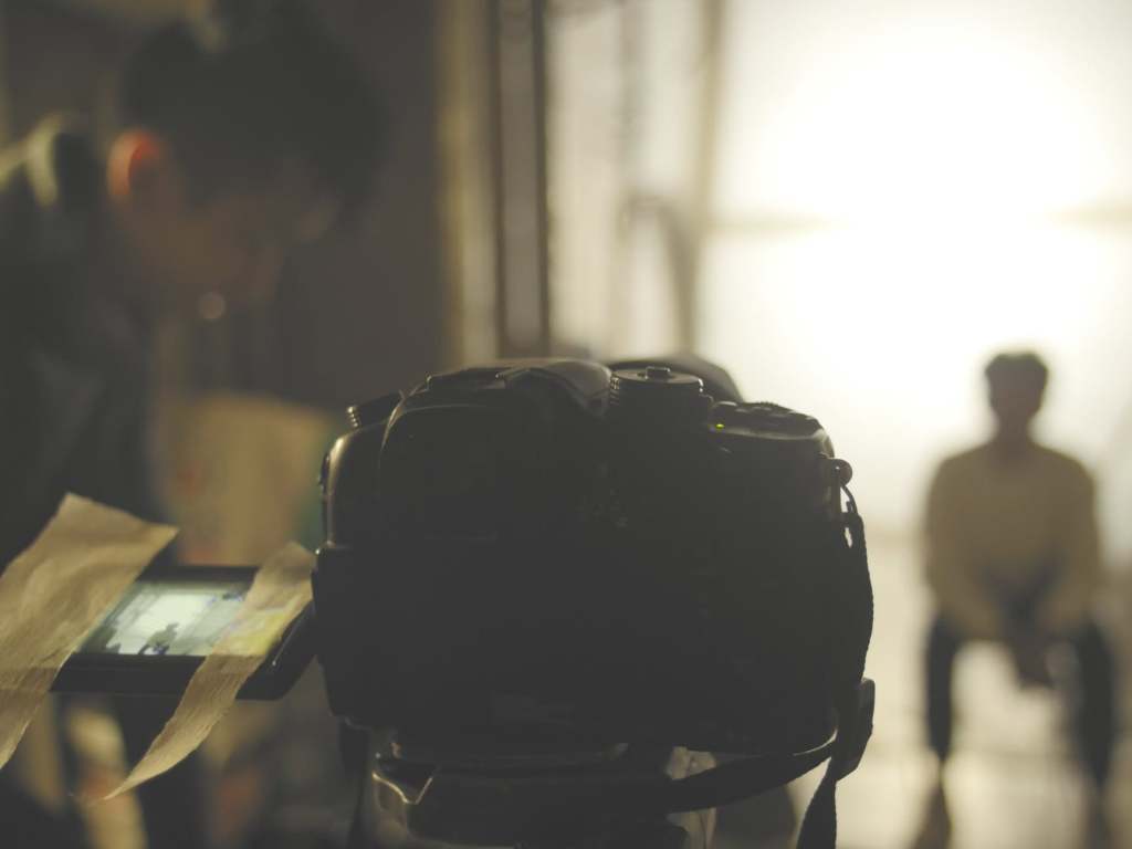 Tournage d'un court-métrage UrbanCiné Kids : caméra au premier plan, acteur en contre-jour